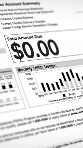 A close-up vertical view of a household electric utility bill rising. Increasing cost of living concept.	 Living paycheck to paycheck concept.