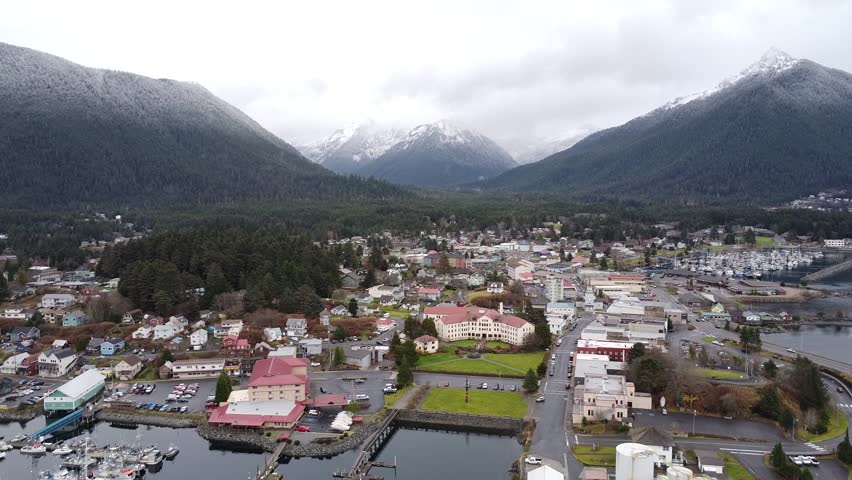 Aerial view of Sitka, Alaska, late winter snowcapped mountains and cold ocean. Cinematic drone video