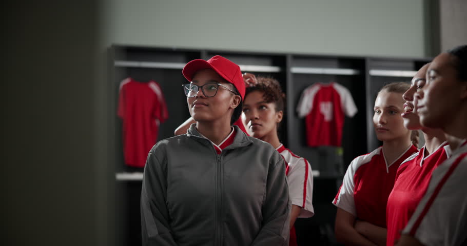 Woman, coach and writing on board with soccer team for direction, formation or strategy for sport in locker room. People, group and football player by club manager for advice, info or notes for game