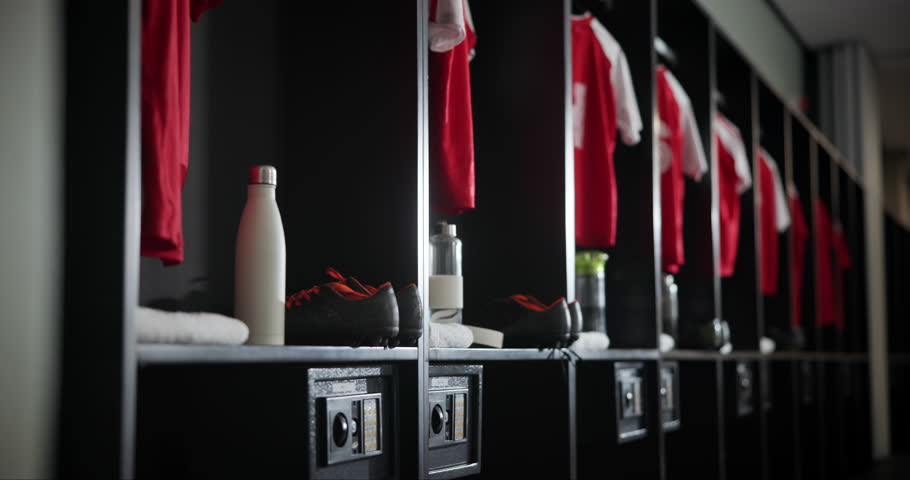 Gym, interior and empty locker room with sport jersey, water bottle and fitness equipment. Soccer, change and uniform at club with clothes, shoes and football cleats in dressing closet for storage