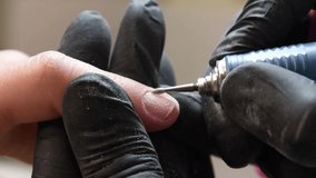 The manicurist grinds off the old coating from the client's nails with the help of a professional electric nail file. High quality photo - Powered by Shutterstock - Get 15% off with code: PIKWIZARD15