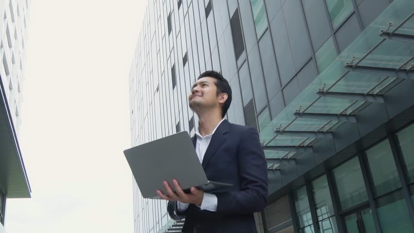 Asian businessman working at laptop showing joy and showing success in investing in financial business investment or wealth.