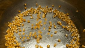 Popcorn grains fall to the bottom of a metal pan with hot vegetable oil. The process of cooking popcorn. Slow motion. - Powered by Shutterstock - Get 15% off with code: PIKWIZARD15