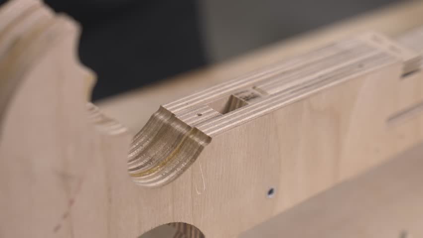 An engineer screws screws and bolts into a wooden airplane model