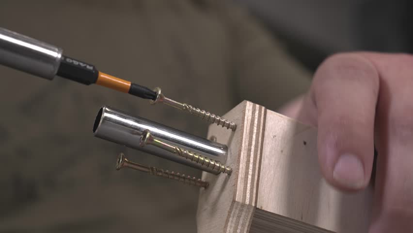 An engineer screws screws and bolts into a wooden airplane model