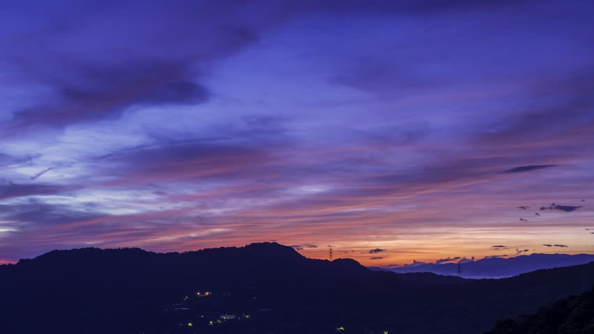 Before sunrise, the colorful clouds in the sky look like alien monsters coming. View of the mountains surrounding Emerald Reservoir. Xindian District, Taiwan.