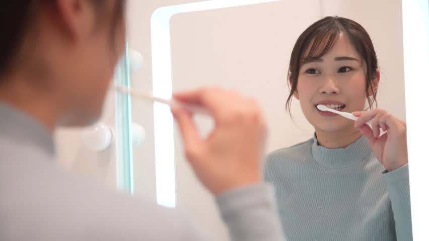 A woman brushing her teeth
