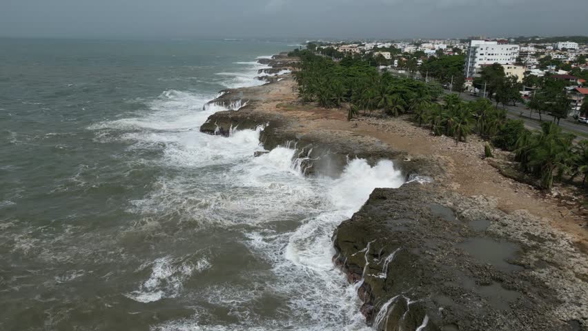Waterfront Malecon coastal promenade of Santo Domingo and waves crashing after hurricane Beryl, Dominican Republic. Aerial drone view
