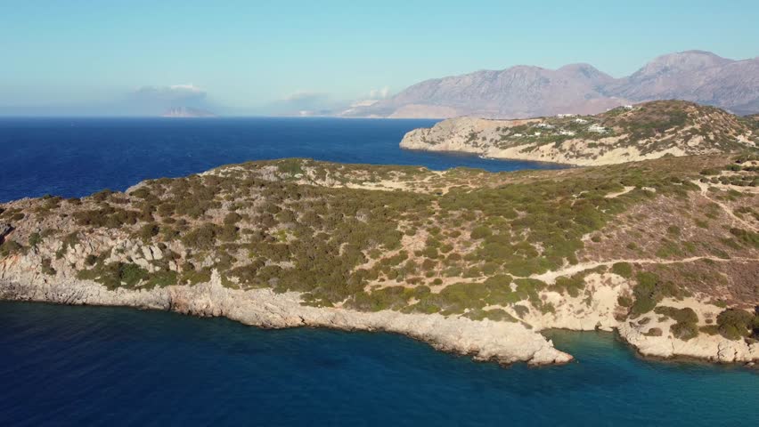 Aerial view of Crete island on a sunny day. Popular tourist destination with mountainous and hilly nature by the sea.