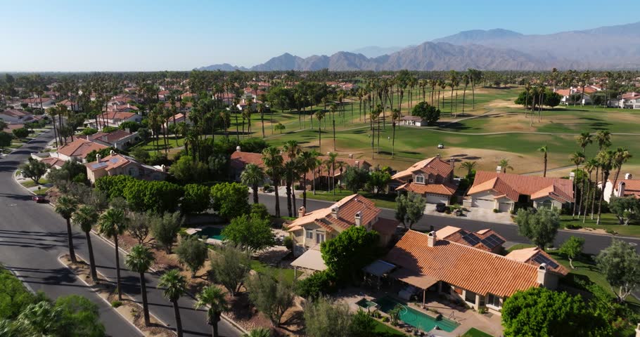 Drone soars above desert trees and golf course in Palm Springs California USA