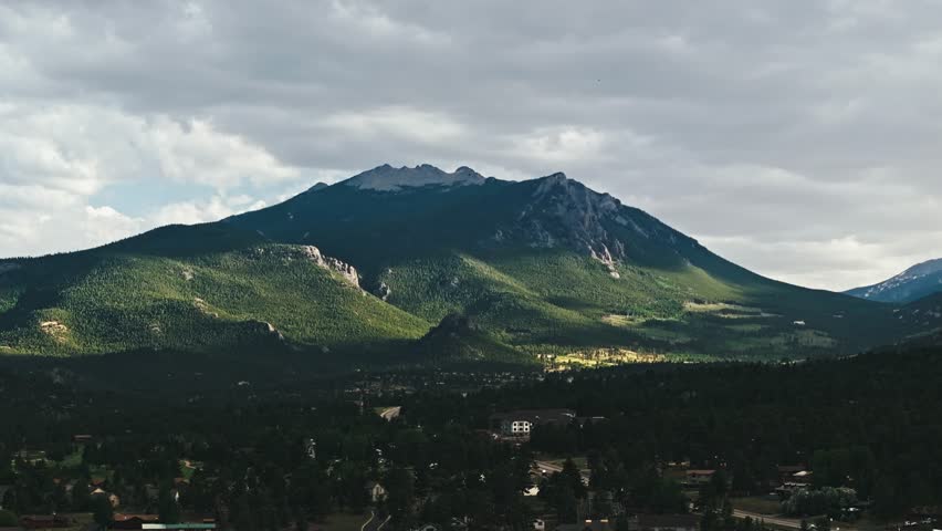 Drone pan left with view of Rocky Mountain peak with snow at top, Estes Park Colorado