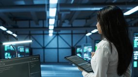 Data center computer scientist designing, implementing and managing infrastructure to ensure optimal performance and reliability. Woman in server room coding on tablet, camera A - Powered by Shutterstock - Get 15% off with code: PIKWIZARD15