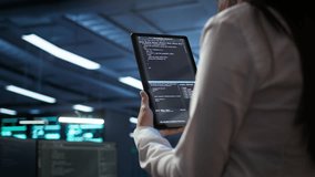 Data center software developer responsible for installation of networking equipment solving tasks on device. Close up of woman doing maintenance on server room infrastructure using tablet, camera B - Powered by Shutterstock - Get 15% off with code: PIKWIZARD15