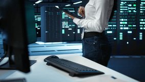 Data center computer scientist designing, implementing and managing infrastructure to ensure optimal performance and reliability. Woman in server room coding on tablet, camera B - Powered by Shutterstock - Get 15% off with code: PIKWIZARD15