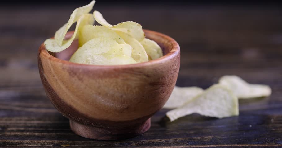 thin potato chips with spices, close-up of a pile of potato chips on the table