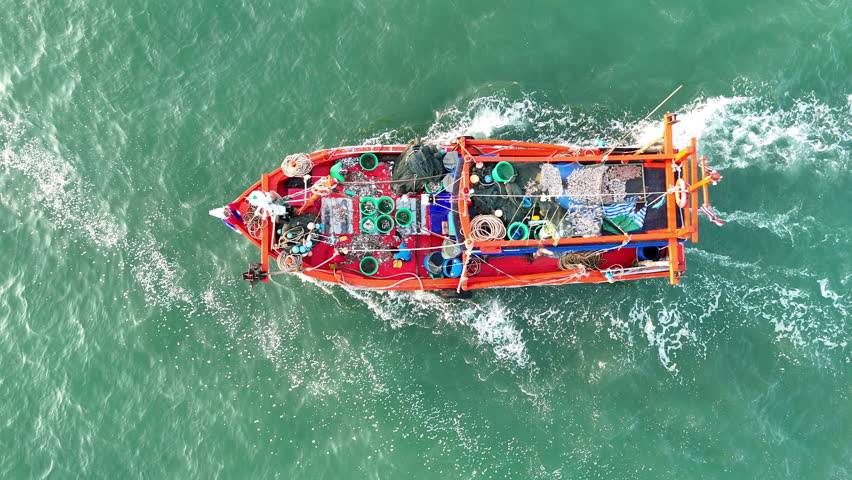 Fishing boat in the ocean for catching fish all a long night - at Thailand. Top view of Fishing Boat running verry fast on the sea to port.