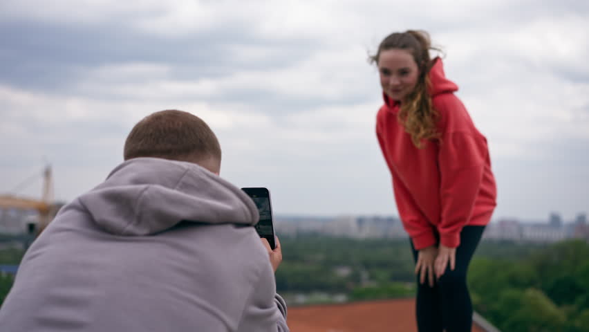 In the park a young couple in love takes pictures after sports photo session after sports active day off
