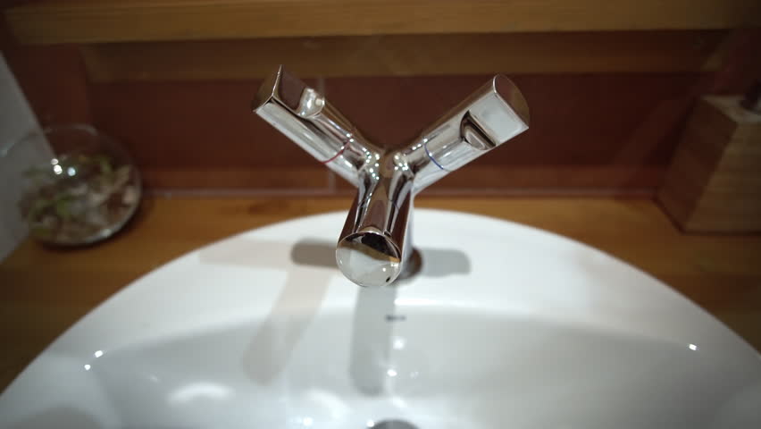 Woman turning tap facet on and off