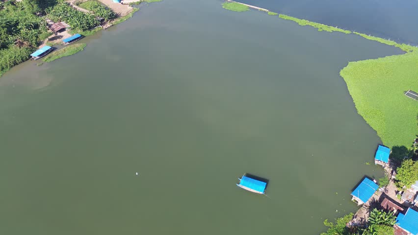 A wooden ship is crossing a river in Indonesia