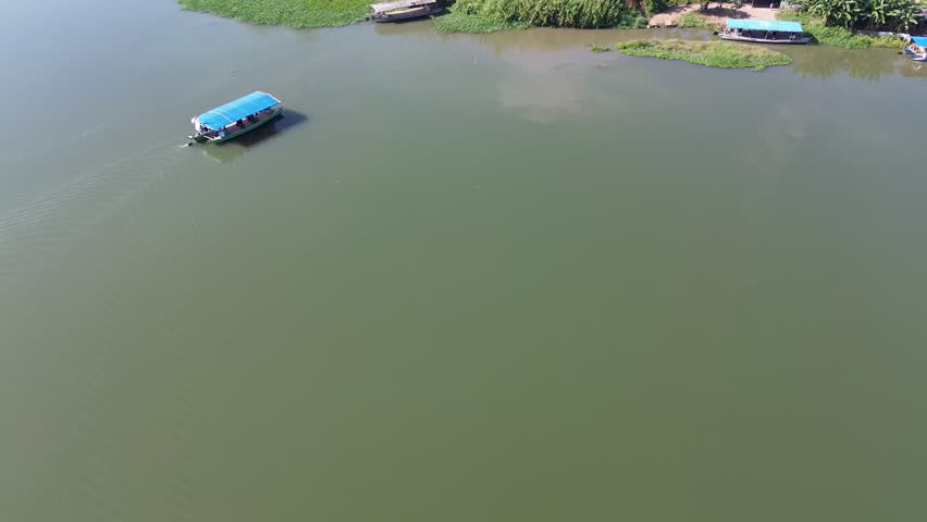 A wooden ship is crossing a river in Indonesia