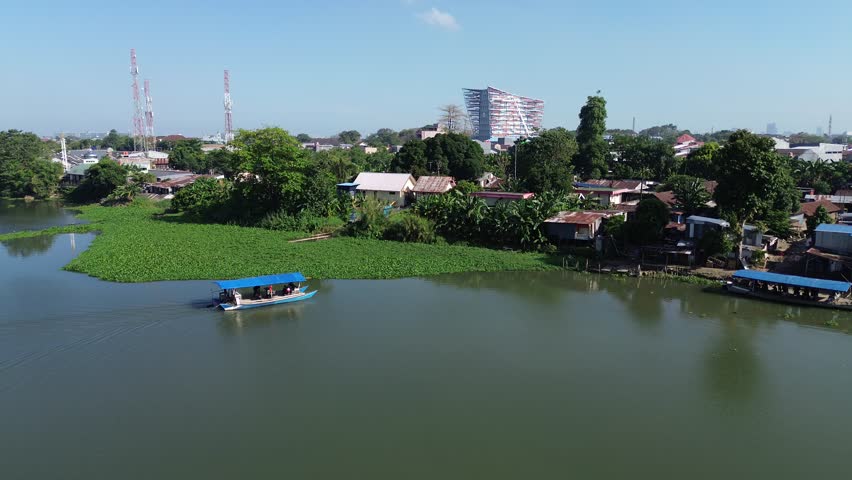 A wooden ship is crossing a river in Indonesia