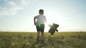 Child playing in nature with bear. Happy Child holding teddy bear. Joyful child running outside. Childhood fun in nature. Summer playtime with bear. Happy Child enjoying nature with bear friend. - Powered by Shutterstock - Get 15% off with code: PIKWIZARD15