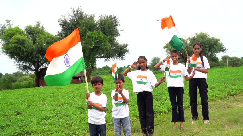 Group of  student or kids wearing indian tricolor Tshirt, face painted with triclolor and saluting. celebrating Independence or Republic day. Har Ghar Tiranga
