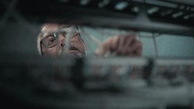 Male network administrator inserts cables into the server rack working with internet equipment in server room. Maintenance of LAN, computer networks and web servers. Data storage center. Close Up. - Powered by Shutterstock - Get 15% off with code: PIKWIZARD15