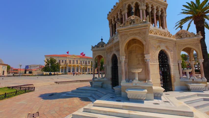 The view of the historical Izmir Clock Tower in the middle of Konak Square and a flock of pigeons, Turkey