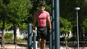 Athlete exercising on parallel bars in a park, performing dips with controlled movements on a sunny day - Powered by Shutterstock - Get 15% off with code: PIKWIZARD15
