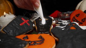 A White Cross Drawn with Sugar Icing on a Coffin-Shaped Cookie, Concept of Sweets in Halloween Symbols. Dolly Slider, Close-Up. - Powered by Shutterstock - Get 15% off with code: PIKWIZARD15