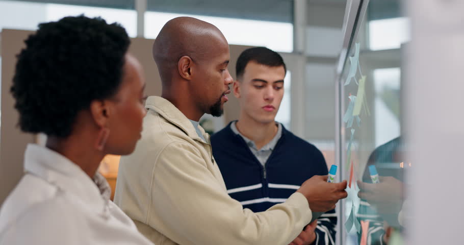 Business people, glass wall and teamwork with tablet, conversation and research for film production. Group, employees and brainstorming with technology, ideas or creativity with story development