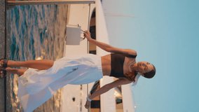 Fashionable model standing sea quay in elegant trendy outfit vertical video. Beautiful confident woman posing in front luxury yacht moored at port. Chic girl relaxing at summer. Carefree vacation - Powered by Shutterstock - Get 15% off with code: PIKWIZARD15