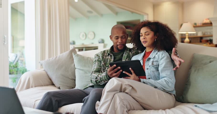 African couple, relax and conversation with tablet on sofa for browsing, property and apartment research. Man, woman and together in house with discussion for real estate investment and housing value