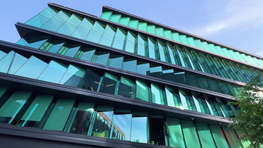 Innovative Green-Tinted Glass Facade: Modern Low-Rise Office in Business Campus | Contemporary Architecture with Reflective Design | Sustainable Corporate Building from Ground Perspective