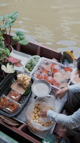 Local food and drink sell on wooden boat floating matket river sstkVertical Bangkok Thailand