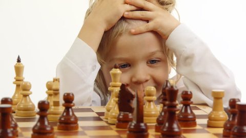 boy thinking and looking at the chess board