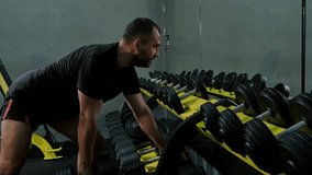 Man athletic workout weight training biceps muscles with dumbbell in fitness gym. Weight training exercise in concept of health and wellness. Bodybuilder shirtless workout at gym. - Powered by Shutterstock - Get 15% off with code: PIKWIZARD15