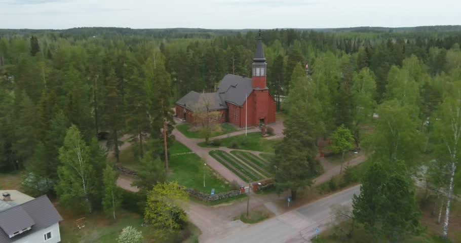 Aerial view of old red brick Ylämaa church in cloudy spring weather, Lappeenranta, Finland.
