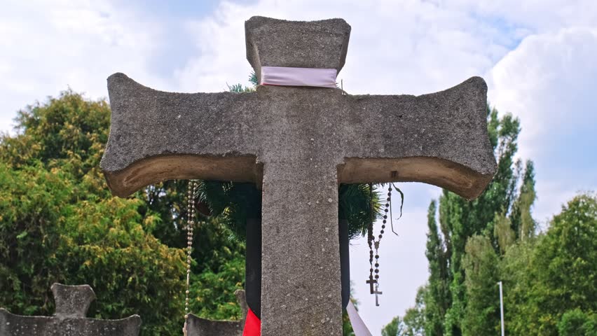 Tomb Cross at Polish Home Army Partisan Soldiers Military Cemetery World War 2 Memorial with Hanging Polish National Flag Band Sash and Prayer Rosary