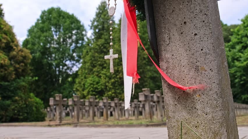 Tomb Cross at Polish Home Army Partisan Soldiers Military Cemetery World War 2 Memorial with Hanging Polish National Flag Band Sash and Prayer Rosary
