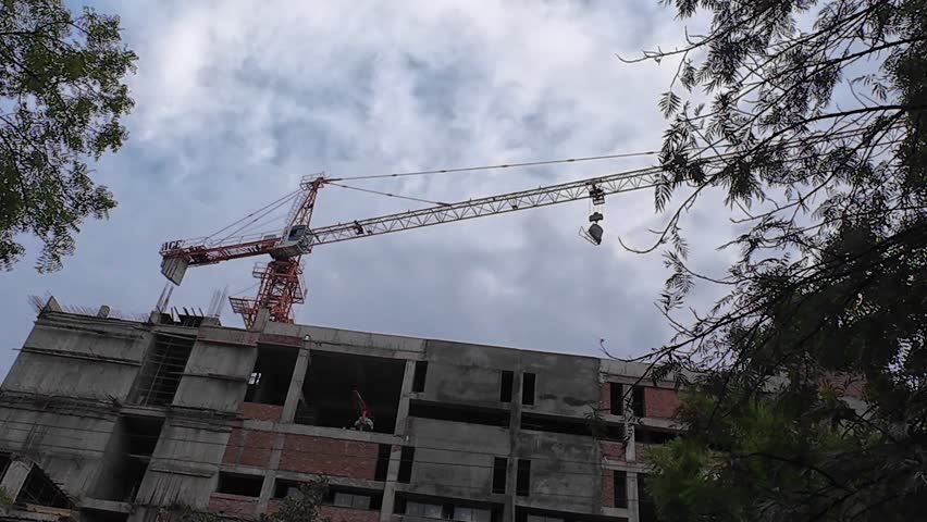 Construction Crane Lifting Building Materials at a Construction Site During Daytime