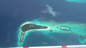 The view from the plane window of the ocean and the atoll. The silver wing of an airplane. There are clouds in places. Turquoise water and snow-white beaches of islands. The Indian Ocean and Maldives - Powered by Shutterstock - Get 15% off with code: PIKWIZARD15