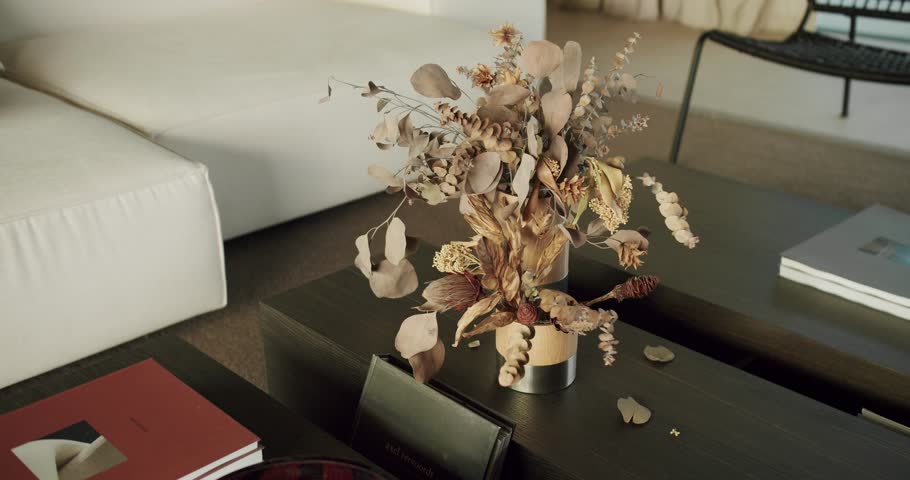A beautfully designed interior showcasing a stylish dried flower arrangement on a dark wooden table, complemented by sophisticated home decor. Dried Flower Arrangement in a Home Interior