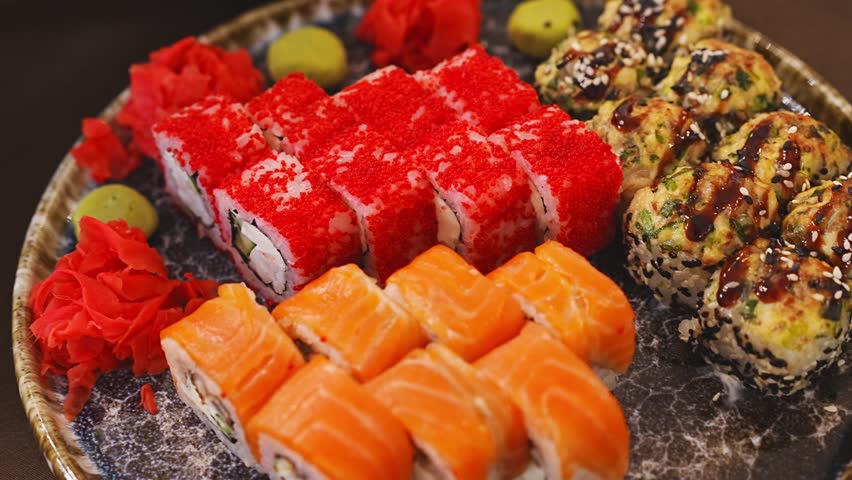 A large plate with rolls. A set of assorted rolls for the holiday. Ordering and delivery of Japanese cuisine.