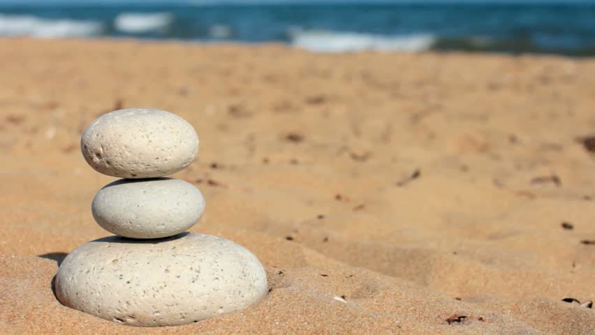 Summer. Wild beach. Someone's hand constructs equilibrium. 