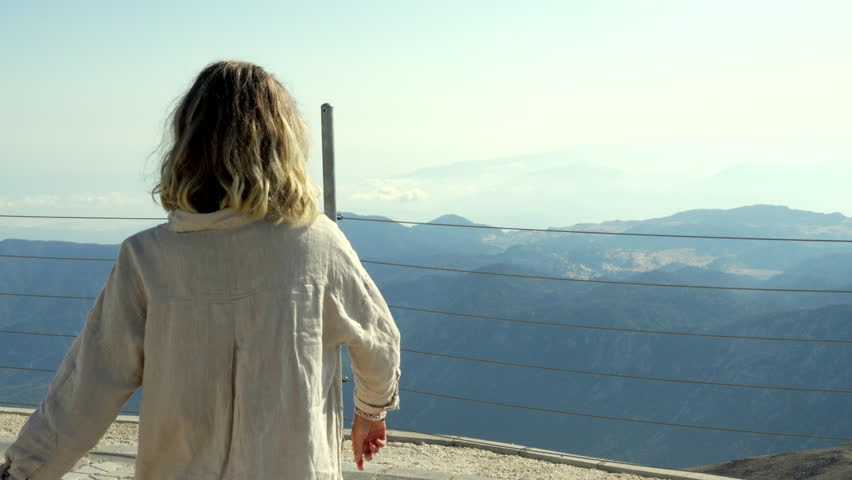The woman enjoying at the mountains.
