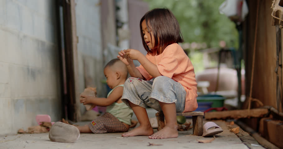A 5-year-old Asian girl who helps care for her baby brother in an old, rundown worker