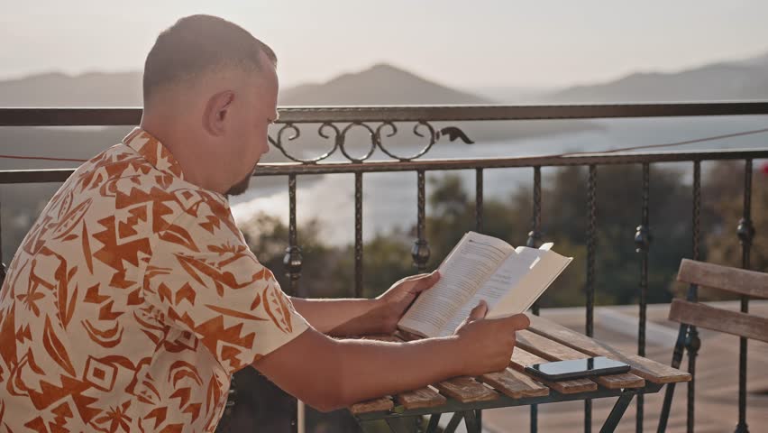 Close-up of a book in the hands of a man.
