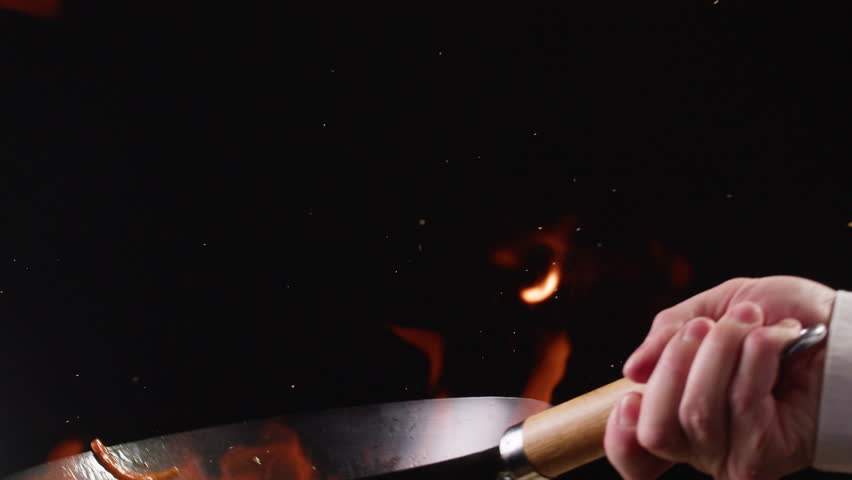 Chef cooking flambe shrimps with oil on wok frying pan close-up. Prawns on fire throwing them in pan. Restaurant Food concept. Sea food.